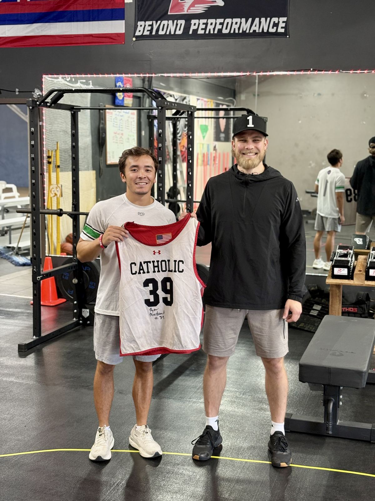 Coach Francis with an athlete holding his jersey